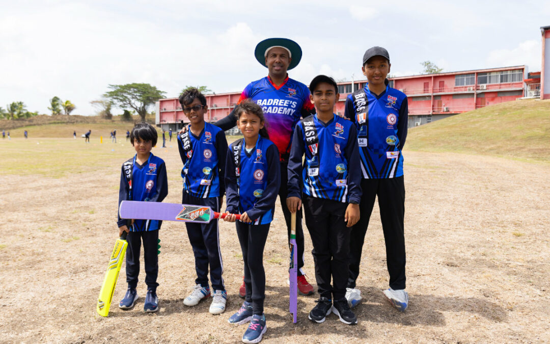 West Indies cricketer Badree standing with his Badree Cricket Academy students