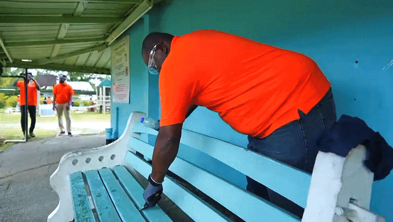 Man painting a school bench blue